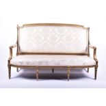 A Louis XVI style gilded sofa upholstered with light floral pattern fabric, the frame with gadroon