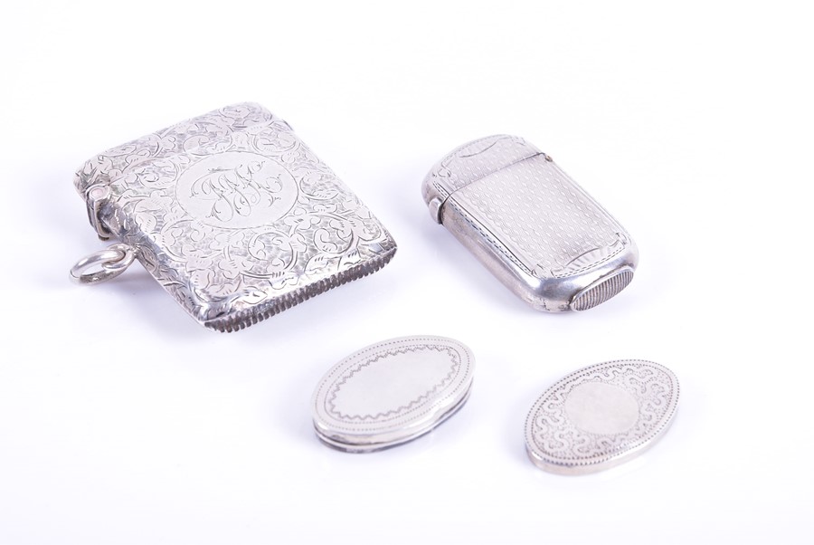 Two silver vesta cases and a miniature pill box the larger vesta decorated with crawling floral work