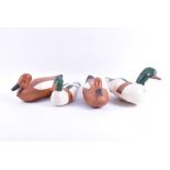 A collection of four early 20th century decoy ducks in painted wood, the largest 21 cm x 37 cm. (4)