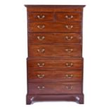 A George III mahogany tallboy with dentil cornice above a graduated set of drawers, two small