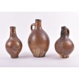 Three 17th century Bellarmine stoneware jugs German origin, two of ovoid for with tall necks and