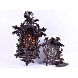 Two Black Forest style cuckoo clocks both with elaborately carved decoration depicting stags,