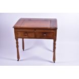 A Victorian ash school masters desk with hinged sloping top, above two drawers each concealing a