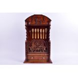 A early 19th century American spoon rack with fretwork panel of horse motifs (split), the domed