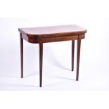 An Edwardian mahogany fold-over card table opening to reveal a green baize, on tapering legs, 90
