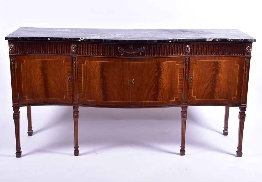 An Adam style marble top sideboard of serpentine form with reeded frieze designed with central urn