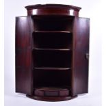 A 19th century bow-fronted wall-hanging corner cupboard with double hinged central doors and