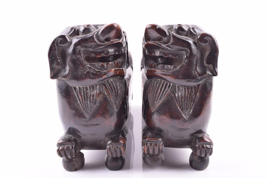 A pair of early Chinese hardwood foo dogs possibly used as scroll weights, the guardians heads sit - Image 2 of 6