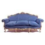 A giltwood framed three-seater sofa  with rococo style scroll decoration, on four front cabriole
