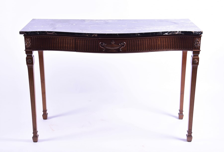 An Adam style marble top console table with serpentine front above a reeded frieze with single