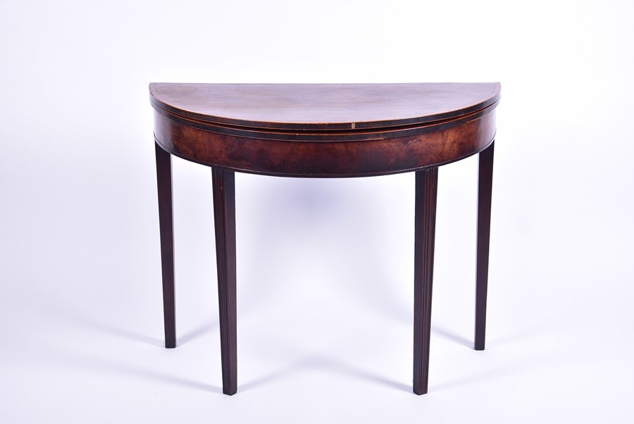 A 19th century walnut demi-lune fold over tea table on tapering legs, 92 cm wide.