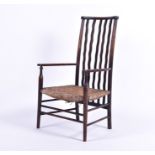 A 19th century rush seated low carver chair in the Arts and Crafts style, the seat 30 cm high.