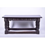 A 19th century oak refectory dining table with carved frieze and stretchers, on turned and block