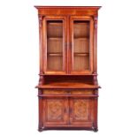 An Edwardian walnut cupboard bookcase with twin-glazed doors over a recessed shelf and two