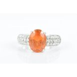 An 18ct white gold, diamond and fire opal ring set with a mixed oval-cut opal, the shoulders pave-
