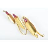 An 18ct yellow gold, diamond, and ruby brooch in stylised foliate form, set with small diamonds