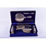 A silver dressing table set in original box Birmingham 1915, comprising mirror, two hair brushes,