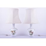 A pair of Herend of Hungary porcelain table lamps painted with birds and insects against an ozier-