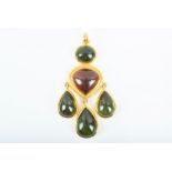 An impressive high carat gold and gemstone pendant set with three pear-shaped peridot drops, beneath