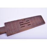 A Polynesian hardwood paddle decorated with pierced head and miniature tightly carved geometric