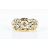 A yellow gold and diamond ring the bombe-style mount pave-set with round-cut diamonds, and centred