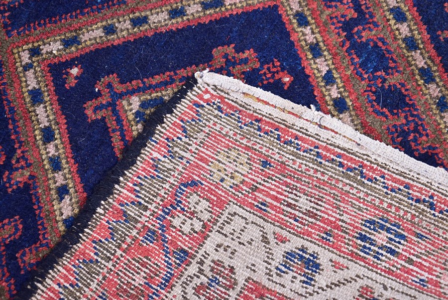 A Persian Qashqai Yalameh wool rug with triple pole medallion in an indigo field, within a triple - Image 2 of 3