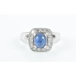 A diamond and sapphire ring set with a cabochon oval-cut sapphire, surrounded with a rounded