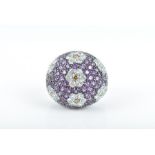 An 18ct white gold and amethyst floral cocktail ring of bombe form, the domed mount studded with