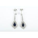 A pair of 18ct white gold, diamond, and sapphire drop earrings the tapered mount suspended with a