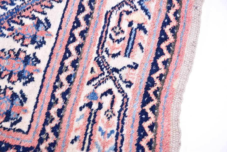A Persian Qashqai carpet designed with central indigo diamond medallion against a salmon pink ground - Image 4 of 4