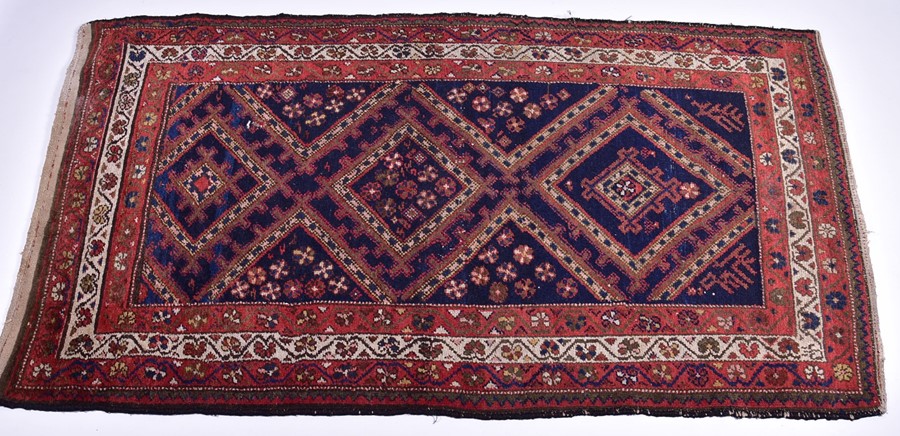 A Persian Qashqai Yalameh wool rug with triple pole medallion in an indigo field, within a triple