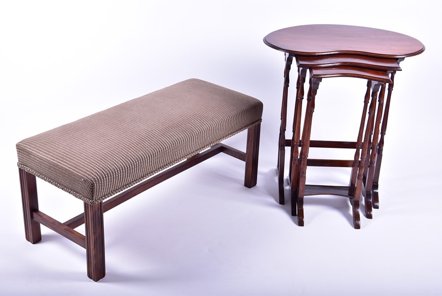 A Georgian style upholstered footstool of long rectangular form, on four reeded square shaped