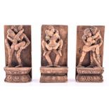 A group of three Indian carved erotic figures each pair of lovers are stood on a double pedestal