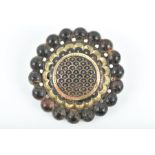 A Victorian faux tortoiseshell brooch of circular form, with damascene gold inlay, within a beaded