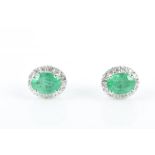 A pair of 18ct white gold, diamond and emerald earrings of oval cluster form, approximately 10 x 7
