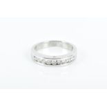 A diamond half eternity ring set with nine round-cut diamonds, set with a small diamond accent to