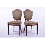 A pair of Victorian dining chairs with upholstered shield shaped backs, both with makers label to