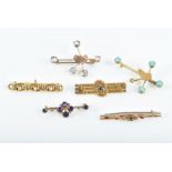 A group of six yellow metal bar brooches to include two gem-set souvenir brooches of Africa, an