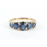 A yellow metal and sapphire ring set with five graduated mixed-cut blue sapphires, shank unmarked (