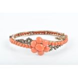 A late 19th / early 20th century coral bangle the gilt metal mount in a crossover style, set with