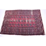 A small Bokhara carpet decorated with black geometric medallions on a red ground, 191 cm x 130 cm.