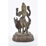 A 19th century Indian bronze figure of a deity with an oxen, mounted to an oval base, 14 cm high. £