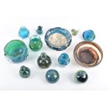 A collection of Mdina studio glass comprising vases, bowls and paperweights, some designed after