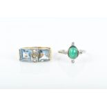 A gem-set ring centred with an oval cabochon untested emerald, flanked at each cardinal point with a