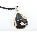 A yellow gold and banded agate pendant set with a pear-shaped cabochon agate, the surmount set