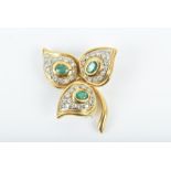 An 18ct yellow gold, emerald and diamond three leaf brooch with a bezel-set emerald to each leaf,