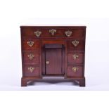 A George II mahogany knee hole desk of small proportions the rectangular top above an arrangement of