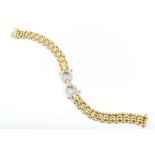 An 18ct yellow gold and diamond bracelet centered with a diamond-set interlocking mount, on