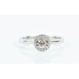 An 18ct white gold, white diamond and pink diamond halo ring set with a round brilliant-cut pink