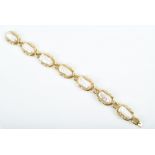 A 14ct yellow gold, diamond and pearl bracelet composed of seven segments, each set with an